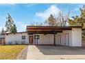 A modern, white home with a unique carport and red front door, complemented by a well-maintained lawn at 330 W Fair Ave, Littleton, CO 80120