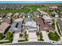 Aerial view of a residential neighborhood, with golf course and green space in the background at 7720 S Queensburg Way, Aurora, CO 80016