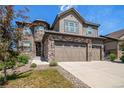 Attractive home showcasing stone accents, a well-manicured lawn, and an attached three car garage at 7720 S Queensburg Way, Aurora, CO 80016