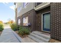 Inviting brick exterior with a blue front door and landscaped walkway at 1615 Harlan St # 2, Lakewood, CO 80214