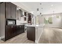 Spacious kitchen with dark wood cabinets, a white countertop island and stainless steel appliances at 1615 Harlan St # 2, Lakewood, CO 80214