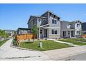 Charming two-story home with gray siding, stone accents, landscaped yard, and inviting curb appeal at 1100 Blue Bell Rd, Berthoud, CO 80513