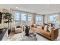 Bright living room with a sleek leather sofa, decorative rug, and large windows offering scenic outdoor views at 4102 Estrella St, Brighton, CO 80601