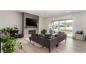 Bright living room with fireplace, sliding glass doors, and comfortable gray sectional sofa at 5839 Hay Market Trl, Parker, CO 80134