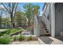 Exterior stairway leading to an upper-level entrance, surrounded by mature trees and lush greenery at 8500 E Jefferson Ave # 11C, Denver, CO 80237