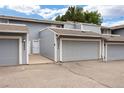 Exterior view of the townhome with gray siding, attached garages, and well-maintained landscaping at 2856 S Kenton Ct, Aurora, CO 80014
