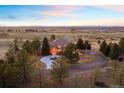 Expansive aerial view showcasing the home's large lot, trees, and mountain views at 7645 Fox Creek Trl, Franktown, CO 80116
