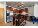 Well-lit kitchen with dark wood cabinetry, stainless steel appliances, and a dining table at 1475 Delgany St # 307, Denver, CO 80202