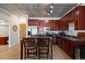 Modern kitchen featuring wood cabinets, stainless steel appliances, and a dining table for four at 1475 Delgany St # 307, Denver, CO 80202
