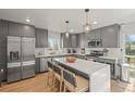 Modern gray kitchen with stainless steel appliances, tile backsplash, and quartz countertop island with seating at 1150 S Forest St, Denver, CO 80246