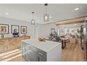 Stylish kitchen island with quartz countertop and pendant lighting overlooks an open living area at 1150 S Forest St, Denver, CO 80246