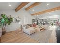 Open-concept living room boasts vaulted ceilings with wood beams, recessed lighting, and view into kitchen at 1150 S Forest St, Denver, CO 80246