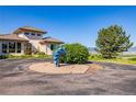 Landscaped circular driveway showcasing a large property with mountain views and blue sculpture at 8611 Coachlight Way, Littleton, CO 80125