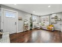Bright living room features hardwood floors, a cozy couch, decor shelving, and an inviting front door at 1010 S Osceola St, Denver, CO 80219