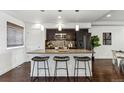Stylish kitchen island with granite countertop, pendant lighting, and dark cabinets, perfect for entertaining at 409 Terry St # D, Longmont, CO 80501