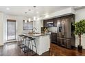 Beautiful kitchen island with granite countertop, dark cabinets, stainless appliances and sleek bar stools at 409 Terry St # D, Longmont, CO 80501