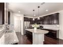 Spacious kitchen with dark wood cabinets, granite countertops, stainless steel appliances, and an island at 690 W 172Nd Pl, Broomfield, CO 80023