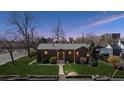 Charming brick home featuring a well-maintained lawn and inviting front entrance at twilight at 1299 S Dale Ct, Denver, CO 80219