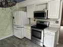Bright kitchen features white cabinets, stainless steel appliances, and modern countertops at 12452 W Dumbarton Pl, Morrison, CO 80465