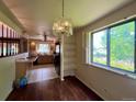 Dining area with hardwood floors, stylish chandelier, and a view of the kitchen, perfect for Gathering meals and entertaining at 7245 S Dexter St, Centennial, CO 80122