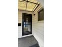 Inviting entrance featuring a black screen door, a light fixture, and white siding at 5030 Beach Ct, Denver, CO 80221