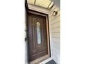 Elegant brown front door with decorative glass panel and secure locking mechanism at 5030 Beach Ct, Denver, CO 80221
