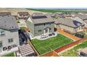 A well-maintained backyard featuring a lush lawn, patio with seating, and a secure privacy fence at 7888 E 139Th Pl, Brighton, CO 80602