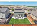 Aerial view of a backyard with a well-maintained lawn, patio area, and privacy fence at 7888 E 139Th Pl, Brighton, CO 80602