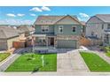 Inviting home with a covered front porch, green lawn, and an attached two-car garage at 7888 E 139Th Pl, Brighton, CO 80602