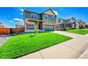 Beautiful two-story home featuring a covered porch, green lawn, and a two-car garage at 7888 E 139Th Pl, Brighton, CO 80602