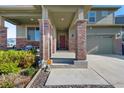 Inviting front porch with brick pillars and a welcoming entrance to the house, offering a cozy seating area at 26909 E Cedar Ave, Aurora, CO 80018