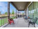 Cozy covered patio with outdoor seating and a view of the fenced backyard at 2932 Eagle Wing Way, Castle Rock, CO 80109