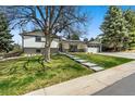 Inviting home with a lush green lawn and stone pathway leading to the front door at 6439 E Maplewood Ave, Centennial, CO 80111
