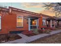 Quaint brick row house featuring well-maintained landscaping and a covered porch entry at 1235 31St St, Denver, CO 80205