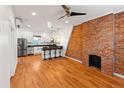 Open-concept kitchen featuring stainless steel appliances, breakfast bar, and brick accent wall at 1235 31St St, Denver, CO 80205