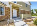 Inviting entrance with stone veneer, a covered porch, and steps leading to the front door at 12704 Jasmine St # E, Thornton, CO 80602