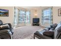 Bright living room featuring bay windows and comfy seating at 12704 Jasmine St # E, Thornton, CO 80602