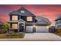 Charming two-story home at twilight, featuring stone accents, a two-car garage, and a well-manicured lawn at 8346 E 132Nd Dr, Thornton, CO 80602