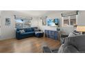Cozy living room with hardwood floors, a comfortable blue sofa, and a flat-screen TV at 3300 Oneida St, Denver, CO 80207