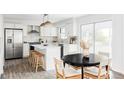 Modern white kitchen with stainless steel appliances and island at 7154 S Hudson Cir, Centennial, CO 80122