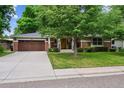 Charming exterior view of home with lush front lawn, mature tree, and a two-car garage at 2957 S York St, Denver, CO 80210