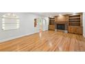 Bright living room featuring hardwood flooring, a fireplace, and open archway to front door at 2957 S York St, Denver, CO 80210