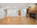 Open living room with gleaming hardwood floors, custom built-ins, and fireplace at 2957 S York St, Denver, CO 80210
