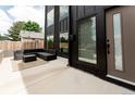 Modern home with black exterior, large windows, and comfortable patio seating area at 2040 W 45Th Ave, Denver, CO 80211
