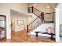 Elegant foyer features hardwood floors, a staircase with decorative wrought iron, and a cozy bench at 580 Crossing Cir, Castle Pines, CO 80108