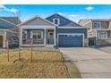 Attractive blue home featuring a well-kept lawn, stone details, and a two-car garage at 18336 Prince Hill Cir, Parker, CO 80134