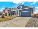 Inviting blue home with two-car garage, stone accents, and spacious driveway at 18336 Prince Hill Cir, Parker, CO 80134