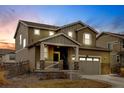 Charming two-story home featuring a two-car garage and a welcoming front porch, stone veneer, neutral color and meticulous landscaping at 5686 Eagle River Pl, Brighton, CO 80601