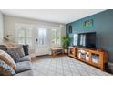 Inviting living room featuring hardwood floors, bright windows, and stylish decor at 6055 E Minnesota Dr, Denver, CO 80224