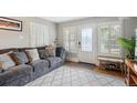 Bright living room with hardwood floors, large windows, and a comfortable gray couch at 6055 E Minnesota Dr, Denver, CO 80224
